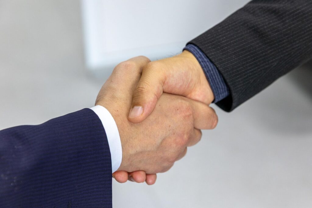 Two professionals shaking hands after reaching a fair agreement